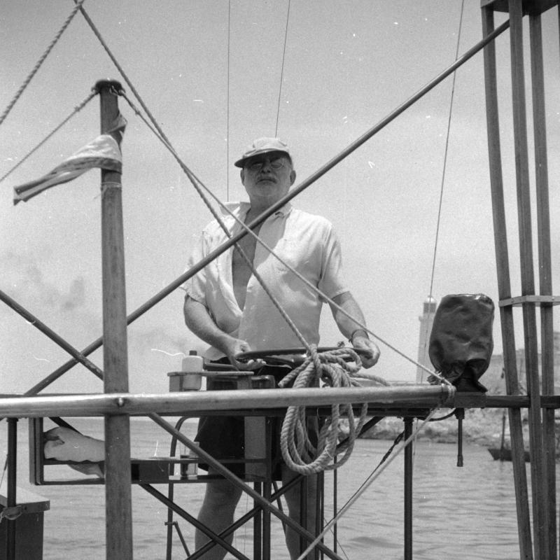 A barefoot Ernest Hemingway on the flying bridge of the Pilar.  Havana Harbor, 1950s.